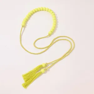 Bohemian style long tassel waist belt detailed view, bright yellow beaded accessory.