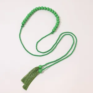 Close-up detail of the boho green wooden bead tassel waist rope, stylish woven cord accessory.