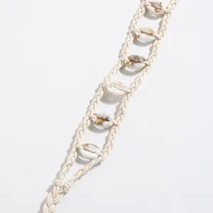 Dettaglio cintura intrecciata stile boho con conchiglie naturali per vacanze estive.