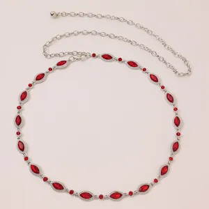 Detailed shot of sparkling red rhinestone waist chain with silver metal links and chain.