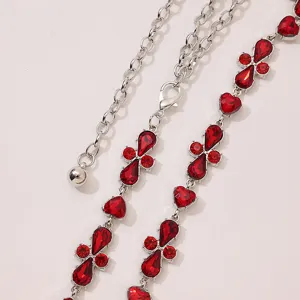 Detailed close-up view of a silver-tone metal waist chain featuring vibrant red crystal stones.
