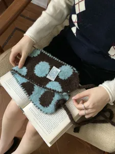 Detailed view of the cozy knitted earmuff with blue and brown pattern, winter style.