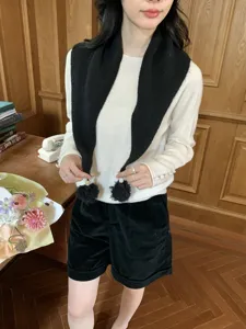 Vista dettagliata della sciarpa triangolare in maglia da donna con pon pon e perline carini.