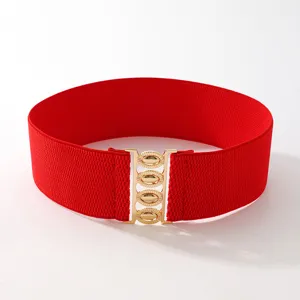 Detail view of the wide red elastic waist belt featuring a stylish gold metal clasp buckle.