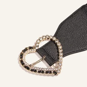 Vista detallada de cinturón ancho elástico mujer con hebilla corazón strass y cadena chic.