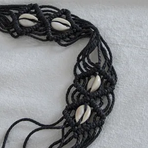 Bohemian handmade black macrame woven waist belt decorated with natural white cowrie shells.