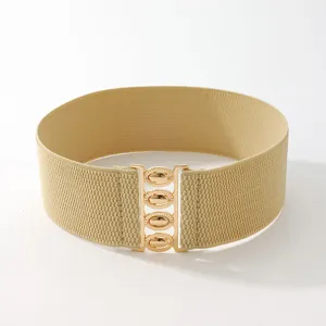Detailed view of the wide elastic waist belt with gold interlocking metal buckle hardware.