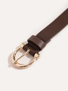 Close-up of women's brown PU leather belt with elegant gold horseshoe buckle detail.