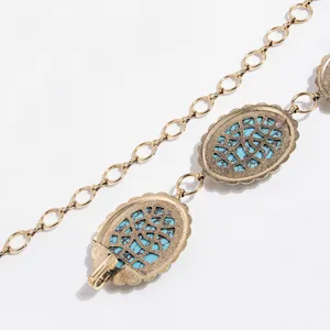 Nahaufnahme der Vintage-Türkis-Metall-Taillenkette mit filigranen geschnitzten runden Elementen.