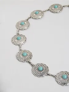 Close-up detail van de westerse boheemse stijl turquoise metalen concho taille ketting.