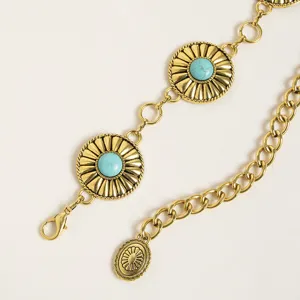 Detailed view of bohemian style metal waist chain with turquoise stones and heavy links.