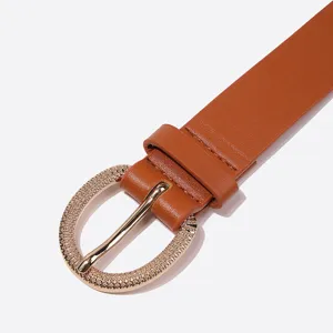 Close-up detail of a vintage brown PU leather women belt with a textured gold oval buckle.