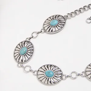 Close-up of western style metal waist chain with turquoise stones and chunky silver links.