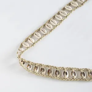 Exquisite detail view of handmade bohemian woven shell belt, natural cowrie shells texture.
