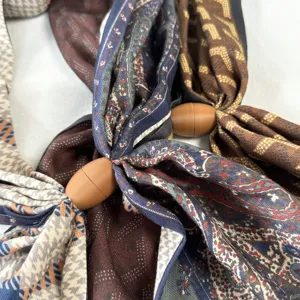 Close-up detail of Maillard floral silk scarves with stylish magnetic buckle accessory.