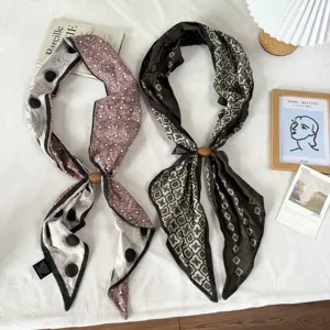 Close-up view of vintage floral silk neck scarves paired with magnetic buckle accessories.