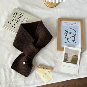 Detailansicht des dunkelbraunen Strickschals im Kreuzdesign, kuschelig und warm aus Wolle.