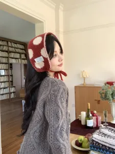Cozy red and white polka dot knit earmuffs detail shot, winter warm ear warmer.