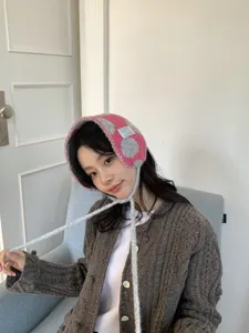Cozy winter knitted plush earflaps with ties, pink and grey double-sided design for warmth.