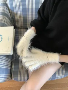 Detailed close-up view of soft fluffy touch screen gloves in white, cozy winter accessory.