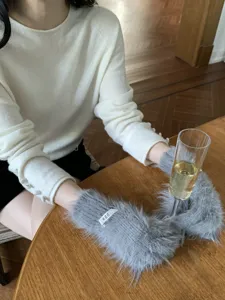 Detailed view of grey fluffy faux mink fur winter warm gloves with cute design and soft texture.
