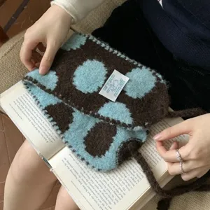Cozy knitted winter ear warmer with cute dot pattern and ties for warm outdoor wear.