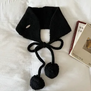 Detailed shot of Korean style black knitted pom-pom ear warmer and tie scarf for cozy winter.
