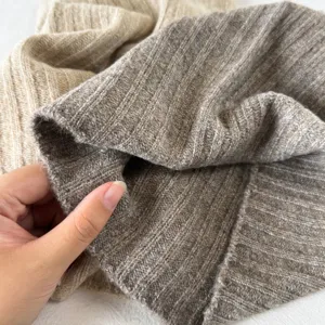 Gros plan détaillé du cache-col en tricot côtelé doux, mettant en valeur la texture et le tissage.