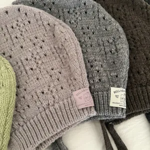 Close-up detail of hollow knitted balaclava bonnet, soft texture and exquisite woven tags.