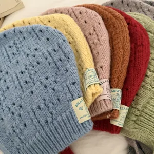 Colorful hollow knit balaclava hat detail shot showing stacked colorful wool beanie designs.