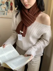 Close-up detail of a brown cable knit wool scarf worn by a model in winter, cozy and warm.