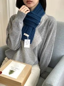 Detail view of women's thick wool cable knit winter scarf, cozy neck warmer accessory.