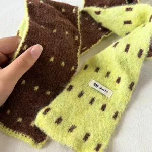 Detailed view of the Korean style color-block knitted scarf, soft texture and cozy wear.