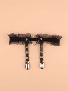 Black gothic lace thigh garter belt detail view, featuring metal heart ring and punk rivet design.