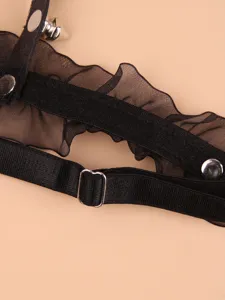 Black lace garter belt detail close-up, elastic thigh strap with metal rivets and adjustable metal buckle.