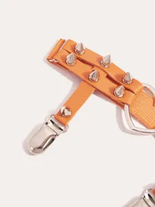 Punk style orange garter belt accessory with metal spikes heart ring and clip detail.