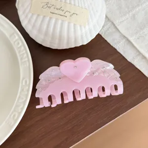 Pink acetate hair claw clip with crystal rhinestones, cute heart and angel wings design detail.