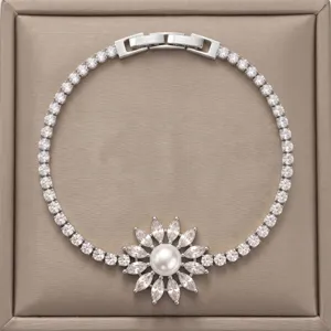 Detalle de una brillante pulsera de tenis de circonita con un elegante colgante de perlas flor.