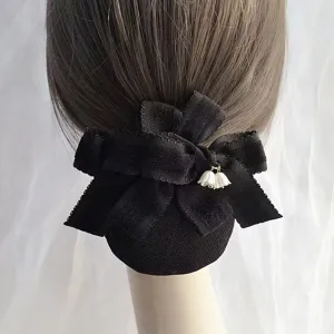 Detailed view of black fabric hair net bow with elegant lily of the valley pendant, back hair accessory.