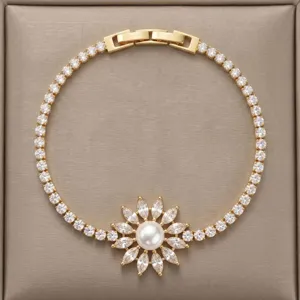 Elegante pulsera dorada con circonitas brillantes y un dije central de perla floral.