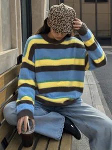 Gros plan sur le pull rayé en fausse vison coloré, mettant en valeur texture et coupe.