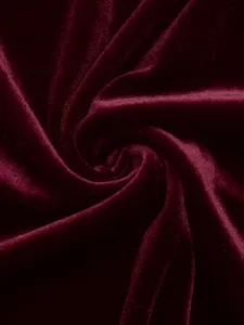 Burgundy velvet fabric detail close up, showing soft texture and luxurious glossy sheen.