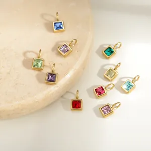 Close-up detail shot of colorful square birthstone stainless steel jewelry charms and pendants.