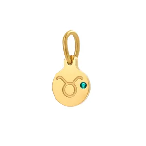 Close-up detail of gold-plated Taurus zodiac pendant with sparkling green birthstone for DIY jewelry.
