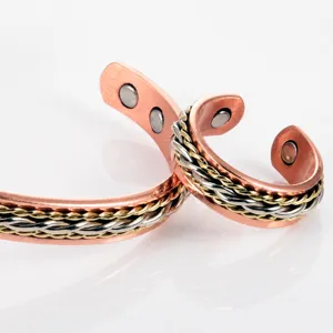 Détail de bague tressée magnétique en cuivre, design ouvert fait main avec des aimants intégrés.