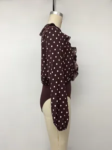Detailed side view of the brown polka dot long sleeve ruffle bodysuit shirt, chic commuting style.
