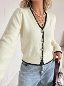 Close-up of contrast trim V-neck knit cardigan featuring metal buttons and layered necklaces.