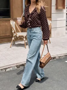 Detail shot of women's polka dot ruffle V-neck long sleeve blouse street style fashion.