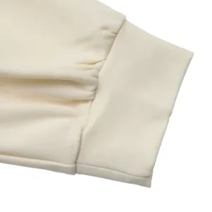 Beige dress sleeve cuff detail featuring a classic ribbed design and elegant pleats texture.