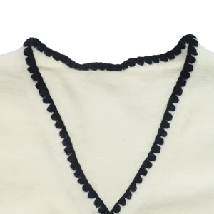 Close-up detail view of women knit cardigan V neckline with black contrast trim texture.